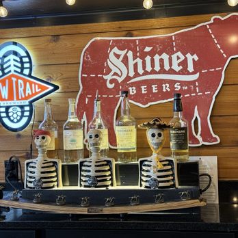 Food & Fire BBQ-Taphouse - Skeletons watching over Blanton bottle stopper display. - Barbeque Near Me - Moosic, Pennsylvania