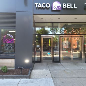 Taco Bell - Exterior view of a Taco Bell restaurant with a sign and logo on the building facade, glass doors, and a sidewalk in front. - Fast Food Near Me - Chicago, Illinois