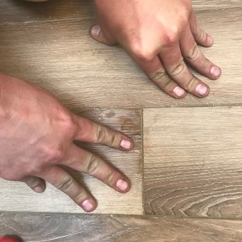 Catspaw Design-Build - a man's hands on a wood floor - General Contractors Near Me