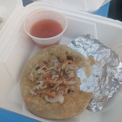 House of Pupusas - Pupusa topped with Curtido and a side of salsa roja.