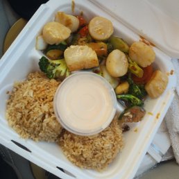 a take out container with rice and vegetables