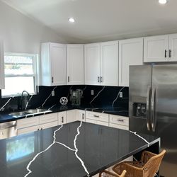 Home Remodeling - The kitchen was remodeled with a white shaker and a dark countertop.