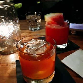 Arbella - 'Smokey the Bear ($15, front) has mezcal and lemon with aromatics. Mystery drink ($13?, back) with watermelon slice and dry spices - Tapas/Small Plates Near Me - Chicago, Illinois
