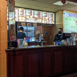 a restaurant counter with a menu in the background a restaurant counter with a menu in the background