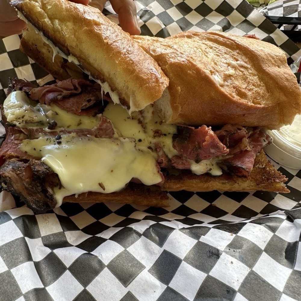 Wyatt’s Place - Grilled pastrami with American cheese on a local fresh baked garlic butter toasted roll. - Sandwiches Near Me - Keaau, Hawaii Wyatt’s Place - Grilled pastrami with American cheese on a local fresh baked garlic butter toasted roll. - Sandwiches Near Me - Keaau, Hawaii