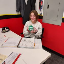 Mathnasium of Papillion - A mathlete holding a Christmas tree stuffie smiles over her work.