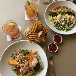 ILIMA'S HAWAIIAN PESTO CRUSTED MAHIMAHI & PRAWN SALAD, ISLAND COBB SALAD, TRUFFLE WAFFLE FRIES. Drinks: Trade Winds, Fresh Fruit Sparkler ILIMA'S HAWAIIAN PESTO CRUSTED MAHIMAHI & PRAWN SALAD, ISLAND COBB SALAD, TRUFFLE WAFFLE FRIES. Drinks: Trade Winds, Fresh Fruit Sparkler