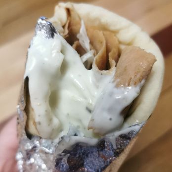 Kojax Souvlaki - a hand holding a burrito - Greek Near Me - Laval, Quebec