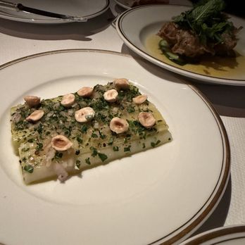 Le Coucou - Poireaux vinaigrette (leeks, hazelnuts) and Lotte frite au sarrasin (buckwheat fried monkfish, cucumbers and curry vinaigrette) - French Near Me - New York, New York