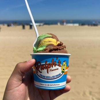Ralph's Italian Ice's - a hand holding a cup of ice cream - Ice Cream & Frozen Yogurt Near Me - Bellmore, New York Ralph's Italian Ice's - a hand holding a cup of ice cream - Ice Cream & Frozen Yogurt Near Me - Bellmore, New York