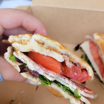 Guichos Eatery - a hand holding a sandwich - Italian Near Me - San Clemente, California Guichos Eatery - a hand holding a sandwich - Italian Near Me - San Clemente, California