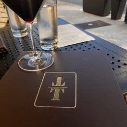 a glass of wine and a menu a glass of wine and a menu