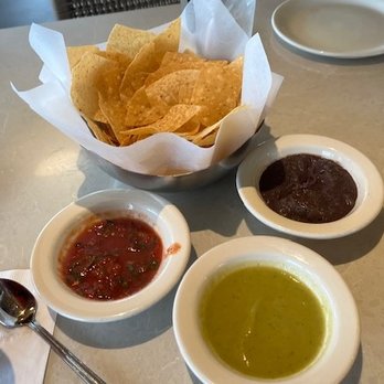 Gloria's Latin Cuisine - Chips with Red salsa, tomatillo salsa and black bean dip. - Tex-Mex Near Me - Shenandoah, Texas Gloria's Latin Cuisine - Chips with Red salsa, tomatillo salsa and black bean dip. - Tex-Mex Near Me - Shenandoah, Texas