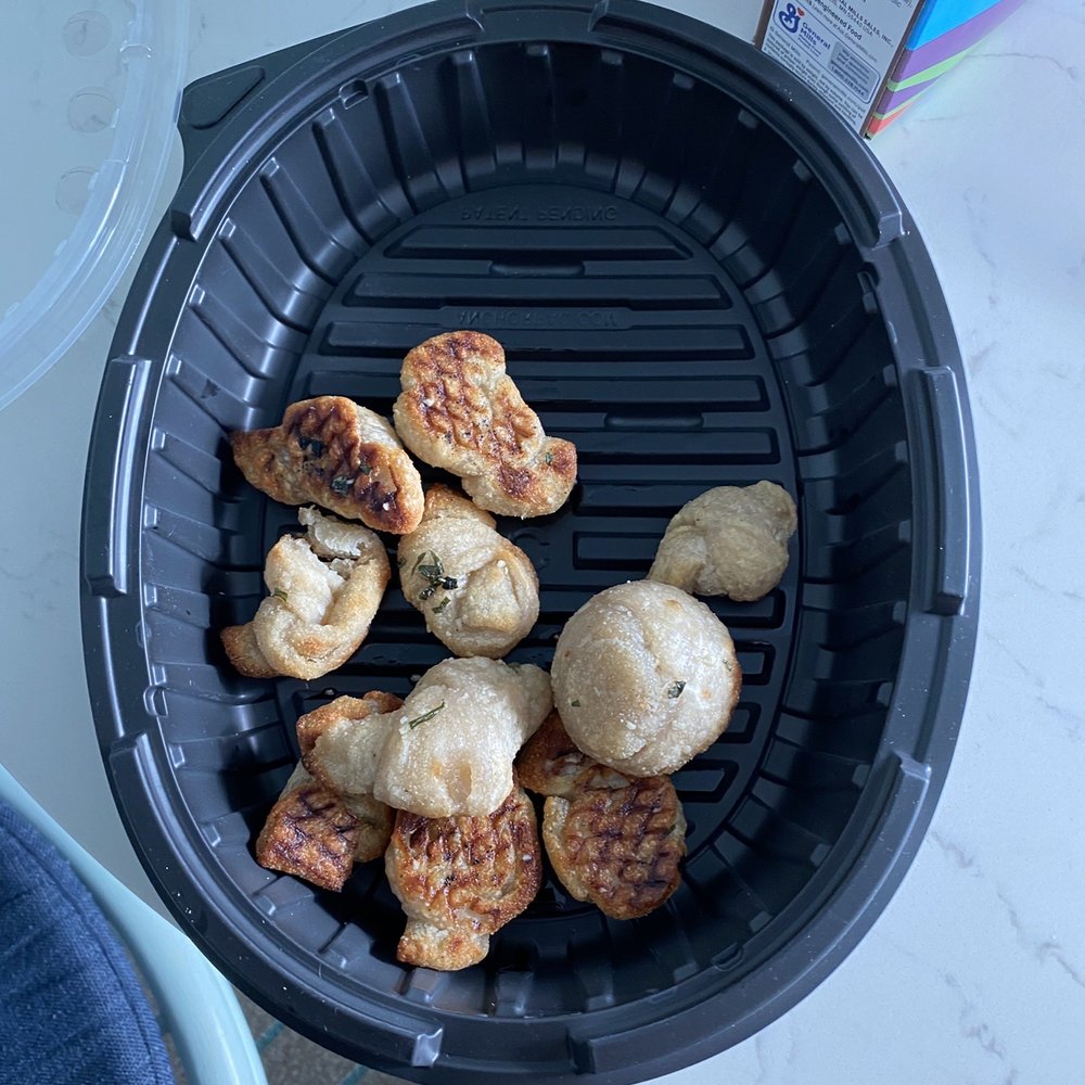 Roundabout Pizza - a person holding a basket of food - Pizza Near Me - Clearwater, Florida