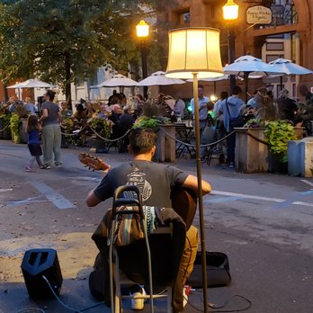 Bacchus - a man playing guitar on a city street - Pizza Near Me - Troy, New York