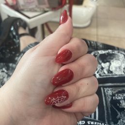 Red nails with a spiderweb design.