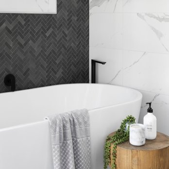 Nouveau Construction - a white bathtub with a wooden stool in front of it - General Contractors Near Me Nouveau Construction - a white bathtub with a wooden stool in front of it - General Contractors Near Me