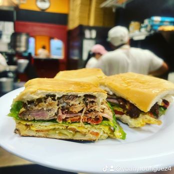 La Guapachosa - a person holding a plate with a sandwich on it - Cuban Near Me - Lakeland, Florida La Guapachosa - a person holding a plate with a sandwich on it - Cuban Near Me - Lakeland, Florida
