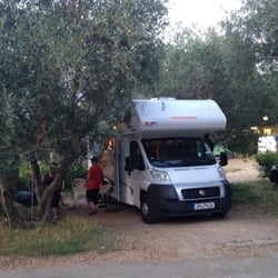 Camping Michelangelo - Large motorhome in camp ground next to olive tree