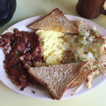 Poor Richards Cafe - A breakfast plate featuring scrambled eggs, two slices of toasted bread, hash browns, and baked beans, served on a white oval dish. - Cafes Near Me - Kalamazoo, Michigan