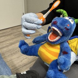 VK Pediatric Dentistry - Getting comfortable before exam by helping to brush the dragon's teeth