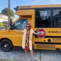 Eagle's Landing Day Camp - A person dressed as a hot dog standing in front of a camp bus