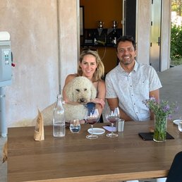 a man and woman sitting at a table with a dog