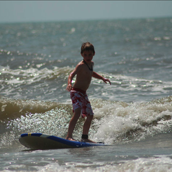 Carolina School of Surf - Tyler surfing a thigh high wave.