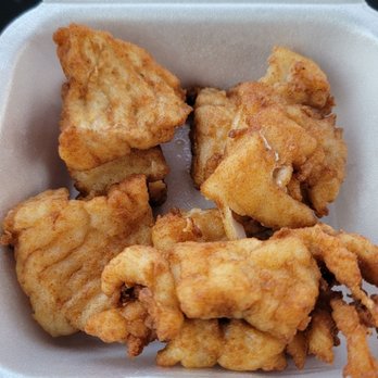 EJ's - Extra piece(s) of fish. Not worth the $9 I was charged. - Four pieces of fried fish are arranged in a foam takeout container, with a golden-brown crispy coating. - Dive Bars Near Me - Hubertus, Wisconsin