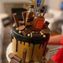 a birthday cake decorated with liquor bottles