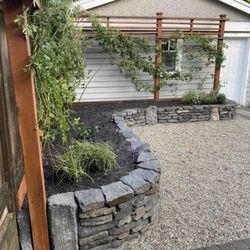 Higher Ground Gardens - Basalt dry stack garden wall and blackberry trellis custom built by our team