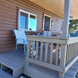 Mystic View Cabins - My fur baby Bella and my husband doing his diamond art on the awesome deck.
