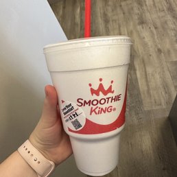 a hand holding a smoothie cup