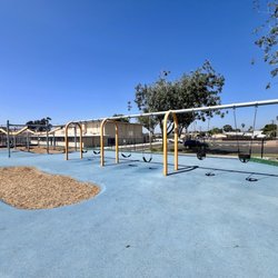 Skyline Hills Park & Recreation Center - 4 regular and 2 infant swings. Sliding mechanisms in background.