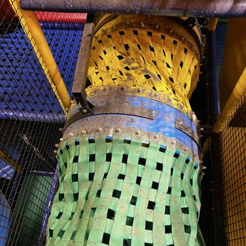 Luv 2 Play Phoenix - Dirty play area - A tunnel slide with woven fabric sides in yellow and green, showing signs of damage and dirt, located in an indoor play area. - Indoor Playcenter Near Me - Phoenix, Arizona
