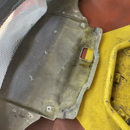 Oil collected in front bumper, discoloration and seepage into the fiberglass.