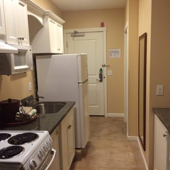 Rivertide Suites Hotel - Full kitchen with plates, silverware, pots and pans, dishwasher, fridge, and recycling bin. - Hotels Near Me - Seaside, Oregon