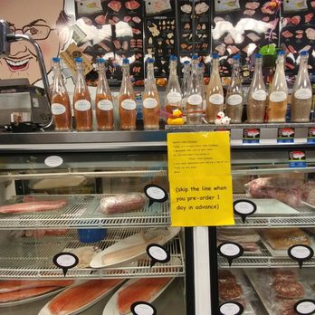 Mitch's Meats & Fish - Meat counter on the right with all of Mitch's spices in bottles on top. These are available for sale! - Butcher Near Me - Roswell, Georgia