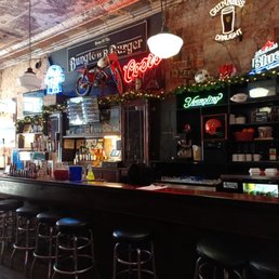 a bar with stools and neon signs a bar with stools and neon signs
