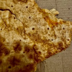 Black specks are wheat flour on the bottom of my gluten free pizza