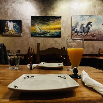 Byblos - a wooden table with a plate and glass of orange juice - Mediterranean Near Me - Baltimore, Maryland