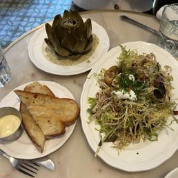 Artichoke, bread with butter, salade lyonnaise Artichoke, bread with butter, salade lyonnaise