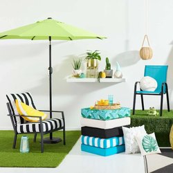 At Home - Colorful outdoor patio cushions arranged neatly on a wicker chair, creating a cozy and inviting outdoor seating area.