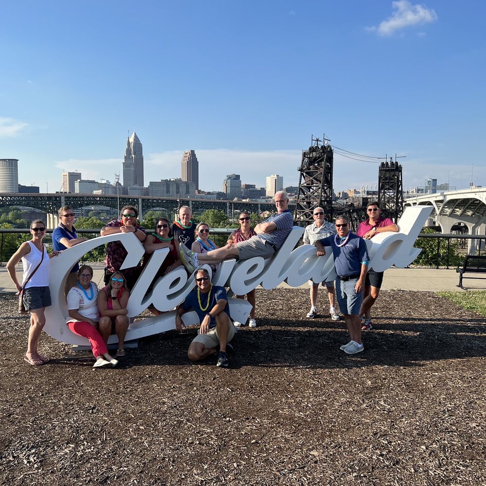 a group of people posing in front of the cleveland skyline