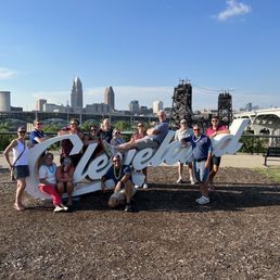 a group of people posing in front of the cleveland skyline