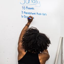 Coach Mo writing up the workout of the day