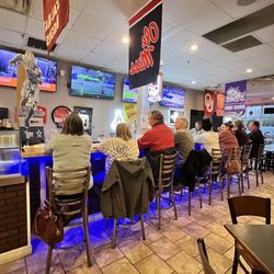 Bar full of customer eating, drinking, and being merry.