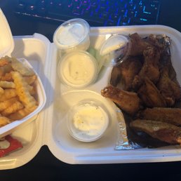 a tray of chicken wings, fries, and dips
