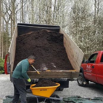 Dino's Landscaping & Masonry - a man dumping dirt into a dump truck - Landscaping Near Me - Danbury, Connecticut Dino's Landscaping & Masonry - a man dumping dirt into a dump truck - Landscaping Near Me - Danbury, Connecticut
