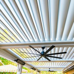 Lush Gardens - A modern louvered patio cover with integrated ceiling fans and outdoor heaters, designed for year-round comfort.